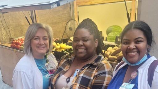 three nurses pose in front of the farmers market