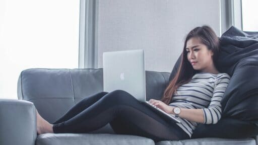 woman sitting on a couch using her compter