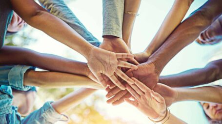 Hands of several people piled together